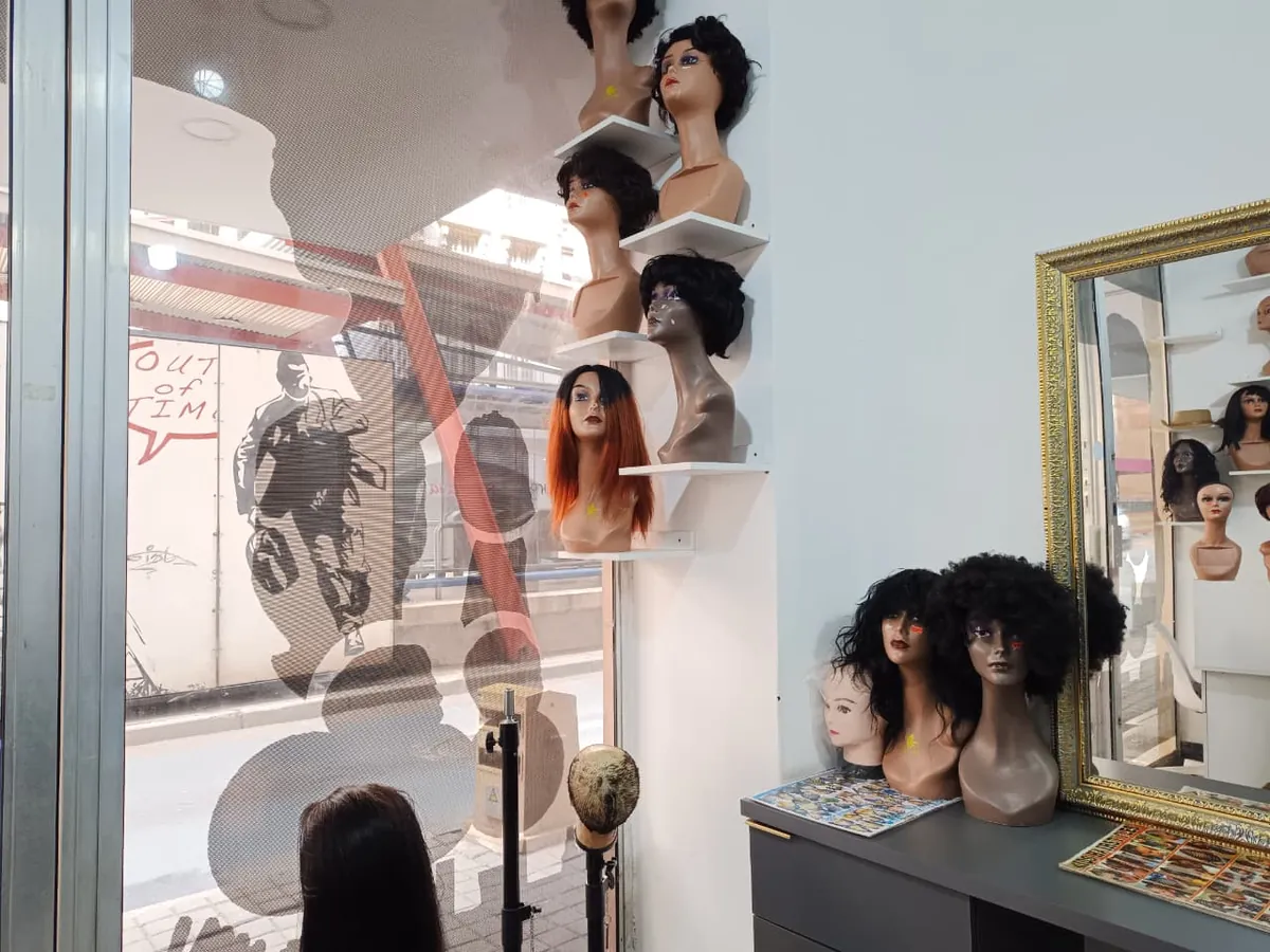 Inside Grace Hair and Beauty Salon — gold-framed mirror and wig display