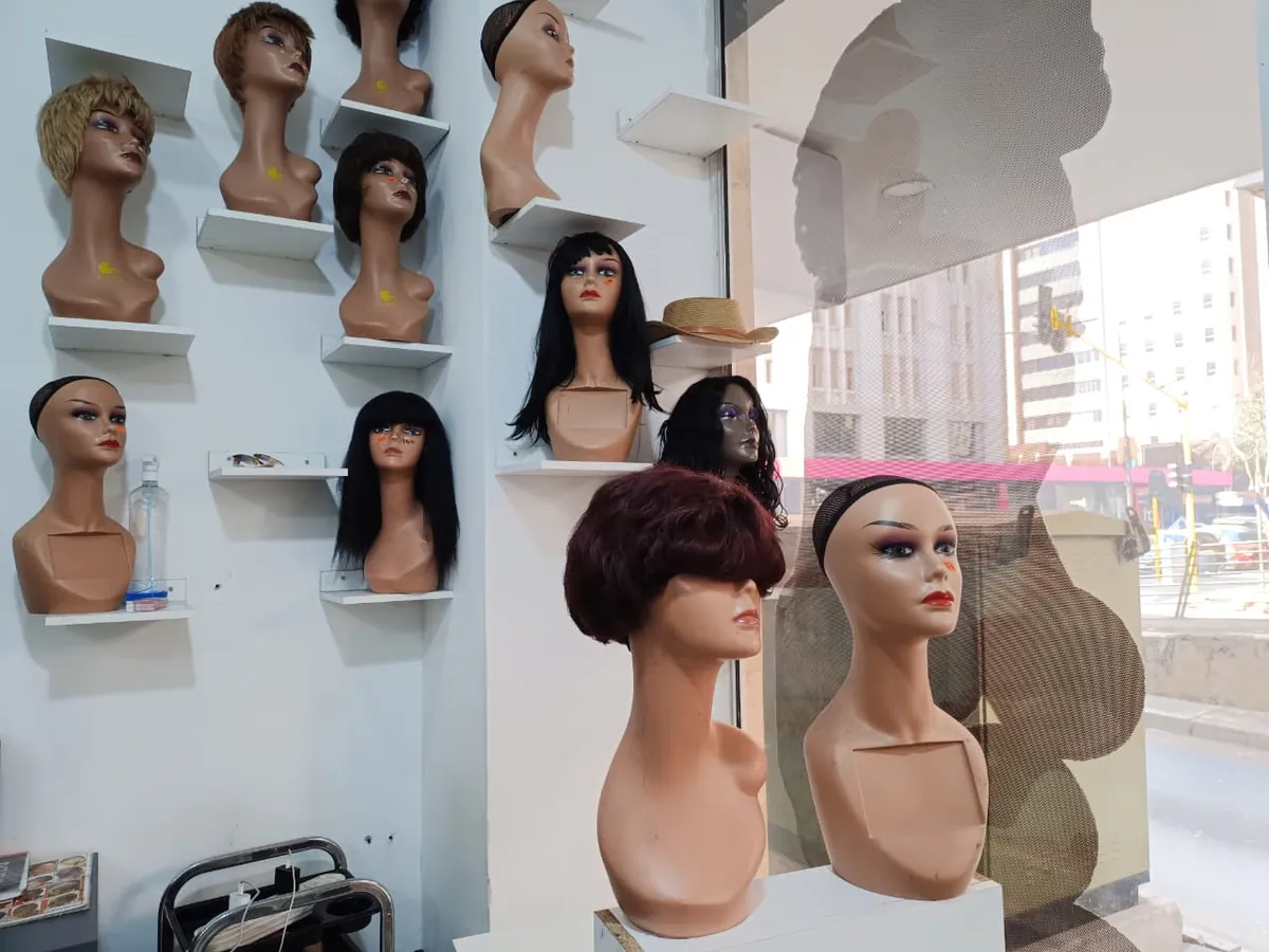 Wigs displayed on shelves inside the salon